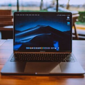 A sleek laptop on a wooden table in a cozy indoor setting, perfect for remote work.